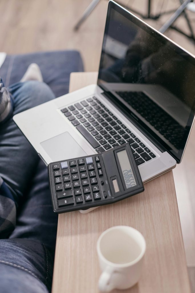 A Laptop and Calculator on a Wooden Table